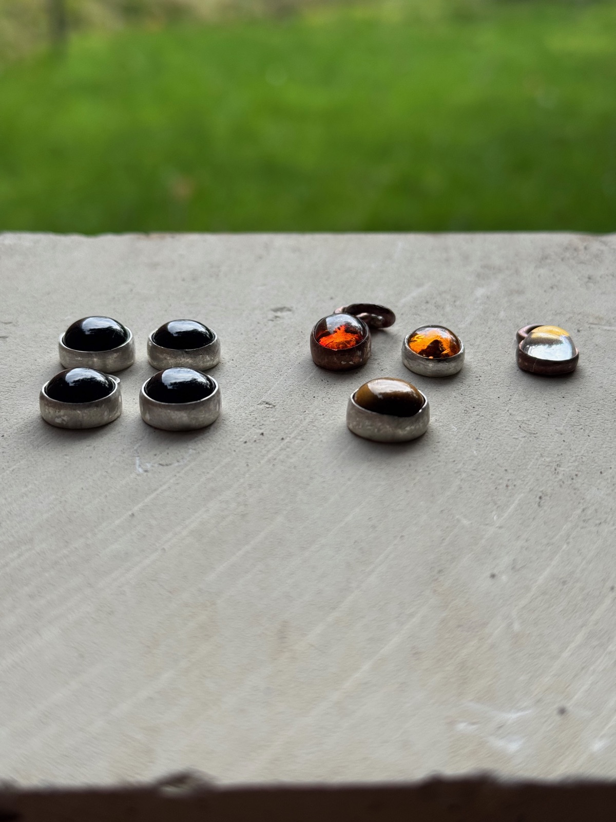 A collection of handmade gemstone pendants resting on stone